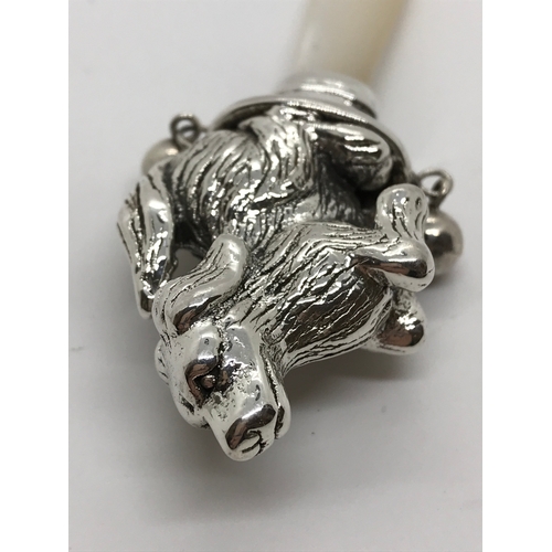 214 - A silver babies rattle in the form of a dog with mother of pearl teether/handle stamped Sterling