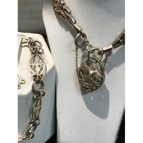 220 - A silver gate bracelet with filigree heart locket and safety chain stamped Sterling plus one other s... 