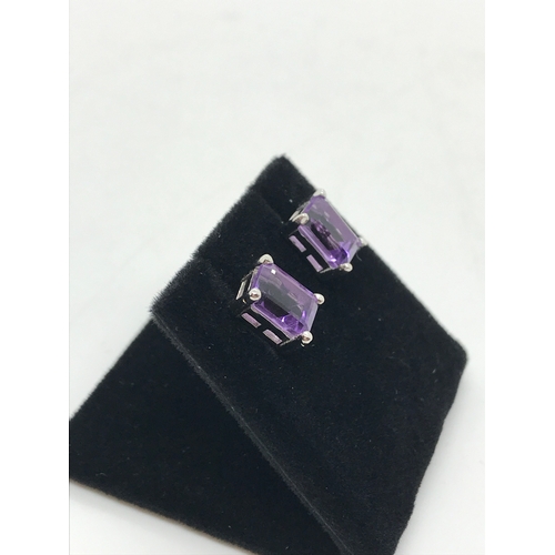 202 - A pair of amethyst stud earrings set on silver posts