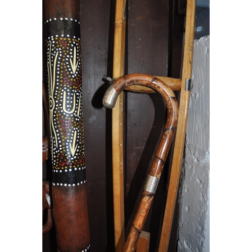 2 - A variety of wooden items including walking sticks, one features a silver collar, a digeridoo, a cru... 