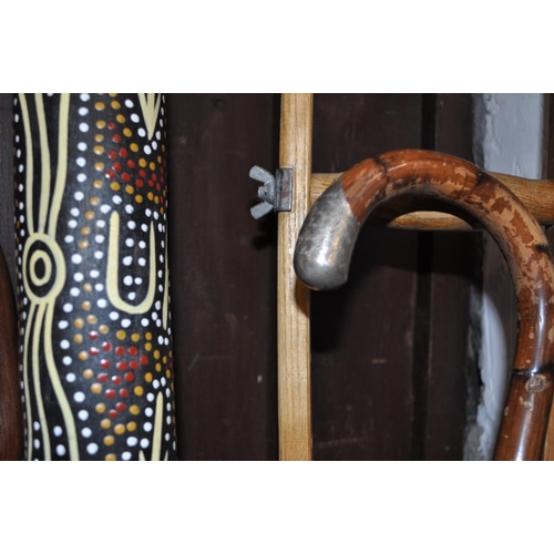 2 - A variety of wooden items including walking sticks, one features a silver collar, a digeridoo, a cru... 