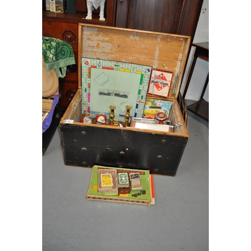 40 - A large wooden box/trunk  containing vintage items including candle holders, book ends, games, pictu... 