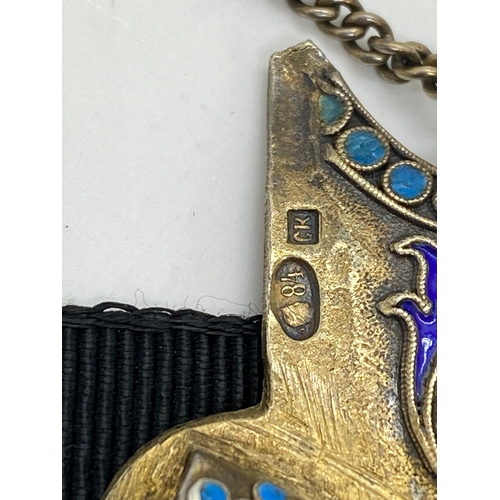 275 - A silver gilt and enamel two piece belt buckle with a jambiya dagger pin and  keeper chain also feat... 