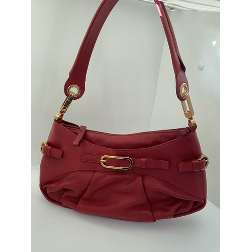 17 - A genuine Coccinelle leather handbag  featuring a striking red soft leather with contrasting gold to... 