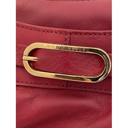 17 - A genuine Coccinelle leather handbag  featuring a striking red soft leather with contrasting gold to... 