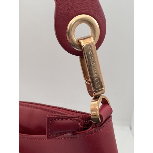 17 - A genuine Coccinelle leather handbag  featuring a striking red soft leather with contrasting gold to... 