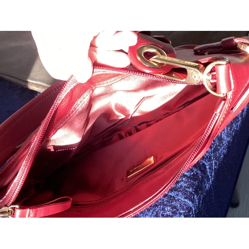 17 - A genuine Coccinelle leather handbag  featuring a striking red soft leather with contrasting gold to... 