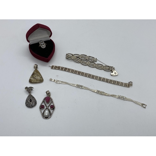 64 - A quantity of silver jewellery including three pendants stamped 925, two silver link design bracelet... 