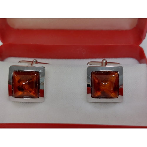 241 - A pair of amber and silver cufflinks stamped 800s presented in Walter Gerdsmeter box