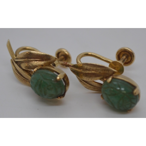 244 - A pair of yellow gold and possibly jade screw back earrings in the form of a flower, carved detailin... 