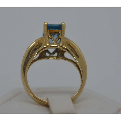 120 - 9ct yellow gold ring with faceted rectangular blue stone - possibly topaz, with co-ordinating square... 