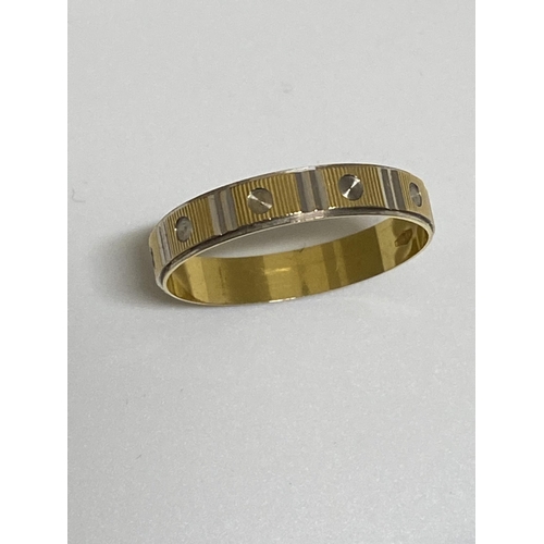 100 - White and yellow gold band ring with screw head design, approx size V, stamped 750, approx 2g