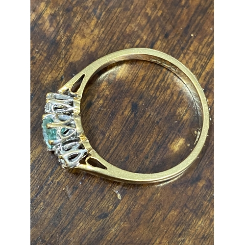 103 - A 9ct yellow gold ring with oval green central stone and a diamond either side of shank, approx size... 