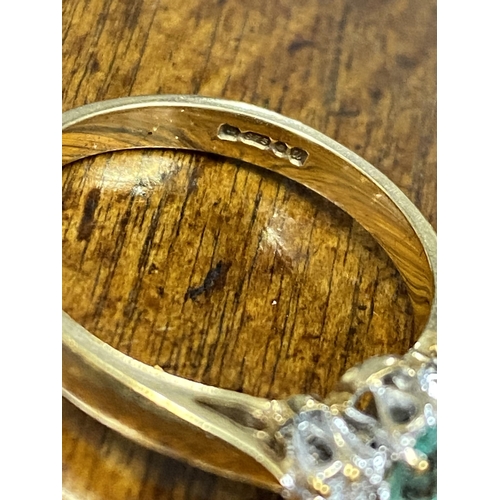 103 - A 9ct yellow gold ring with oval green central stone and a diamond either side of shank, approx size... 