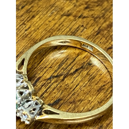 103 - A 9ct yellow gold ring with oval green central stone and a diamond either side of shank, approx size... 