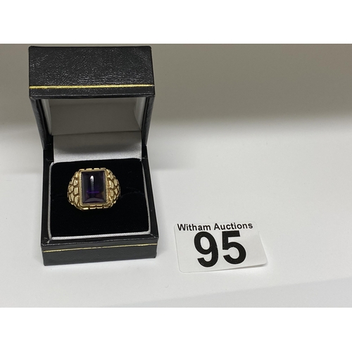 95 - A 9ct yellow ring, hallmarked London  with polished purple raised stone, with a patterned design to ... 