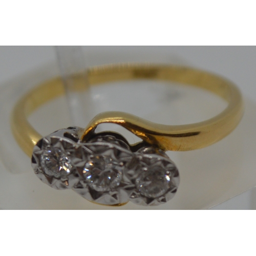 87 - 18ct yellow gold tri-stone diamond ring in  a cross over design setting, marked 18CT, approx 0.20CT,... 