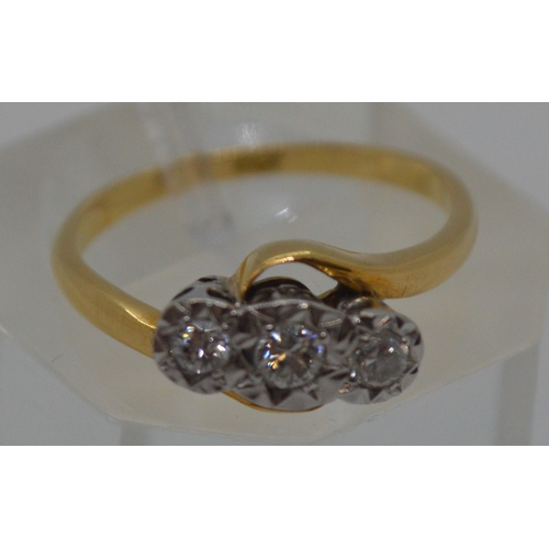 87 - 18ct yellow gold tri-stone diamond ring in  a cross over design setting, marked 18CT, approx 0.20CT,... 