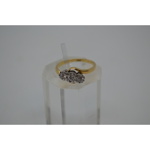 87 - 18ct yellow gold tri-stone diamond ring in  a cross over design setting, marked 18CT, approx 0.20CT,... 