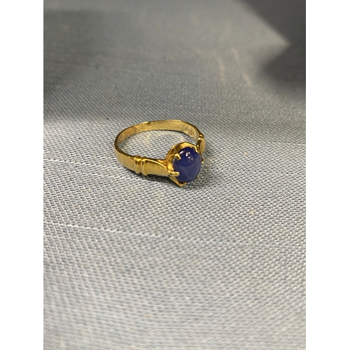 119 - 18ct yellow gold ring with claw setting encapsulating oval semi precious blue stone, approx size M, ... 