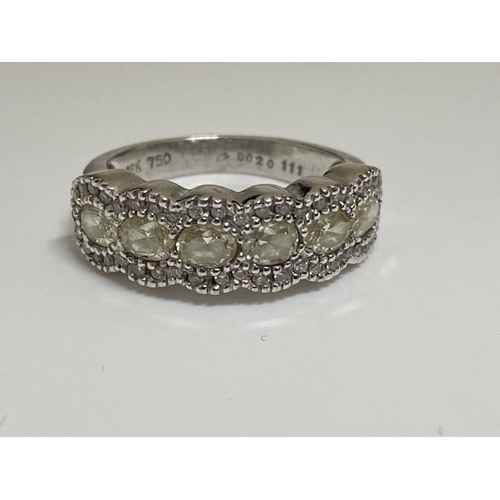 128 - Ladies white gold eternity ring, with central row of oval cut diamonds with smaller chip diamonds to... 