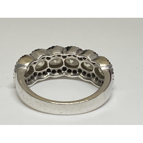 128 - Ladies white gold eternity ring, with central row of oval cut diamonds with smaller chip diamonds to... 