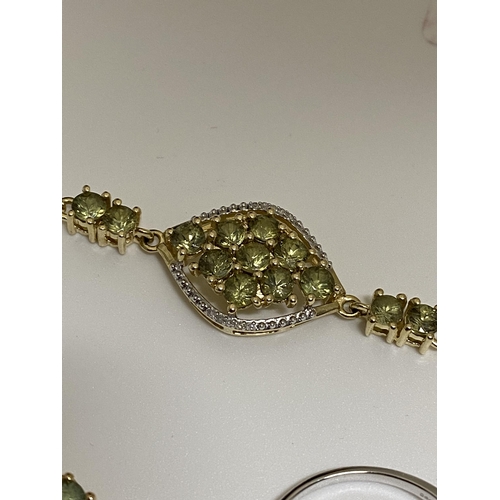 134 - A Peridot 10k yellow gold pendant with matching bracelet marked 10k together with a Peridot white go... 