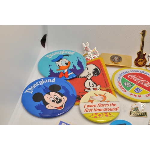 218 - A large quantity of pin badges and novelty keyrings, to include Disney's Mickey and Donald, Snoopy, ... 