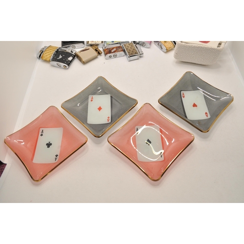 54 - A selection of 10 small lighters, with two sets of four ceramic and glass ashtrays with playing card... 