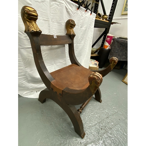 130 - Statement chair with carved monkey head design. Leather seat has oversized hammered iron tacks