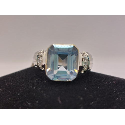 71 - 18ct white gold ring with large aqua stone to central design, hallmarked. Approx size Q