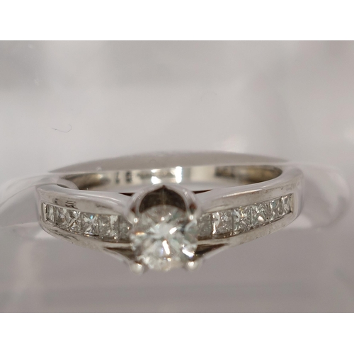 78 - 18ct white gold diamond ring, central round cut stone of approx 0.20ct, with additional x12 princess... 