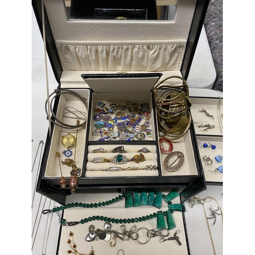 130 - A jewellery box containing a quantity of costume jewellery to include silver chains, bracelets, ambe... 