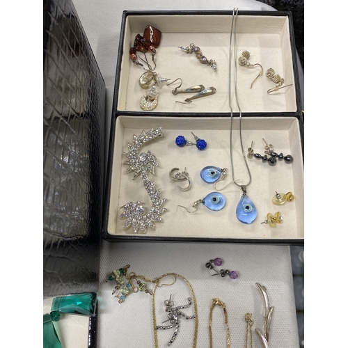 130 - A jewellery box containing a quantity of costume jewellery to include silver chains, bracelets, ambe... 