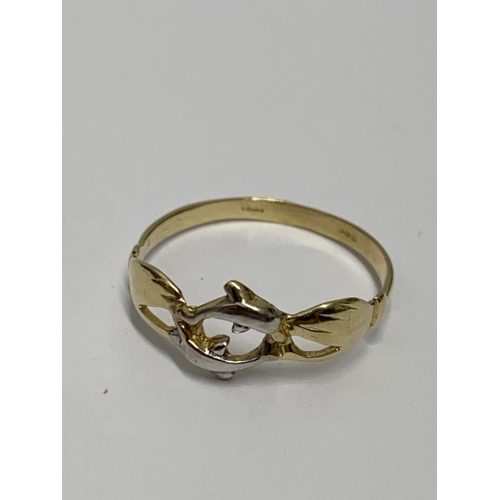 217 - A yellow gold ring with design depicting two hands holding a pair of dolphins, stamped 18kt (tested)... 