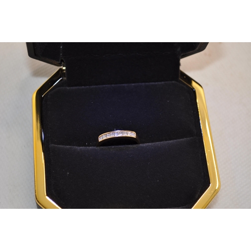 189 - An 18ct gold ring with a row insert channel of 9 princess cut diamonds Approx. size M