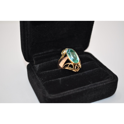 194 - Yellow gold ring with large central stone (possibly Aquamarine) with decorative scroll mount, size P