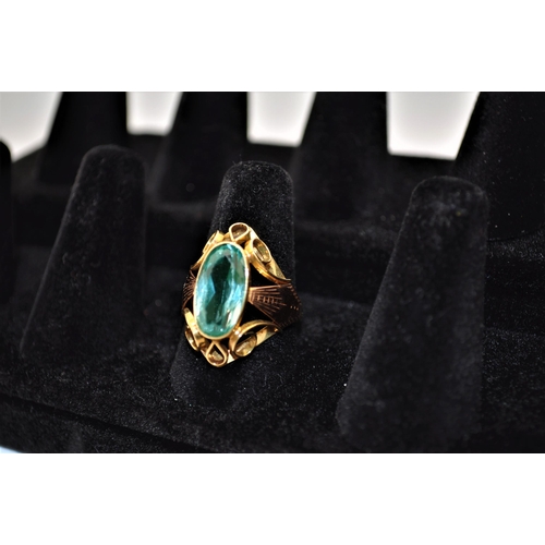 194 - Yellow gold ring with large central stone (possibly Aquamarine) with decorative scroll mount, size P