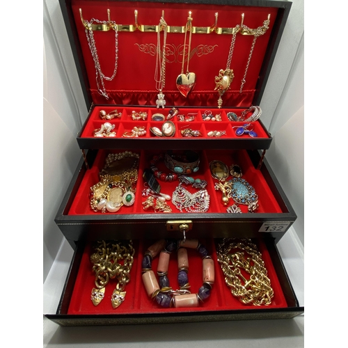 132 - A jewellery box containing a large quantity of costume jewellery to include lockets, snake rings, br... 