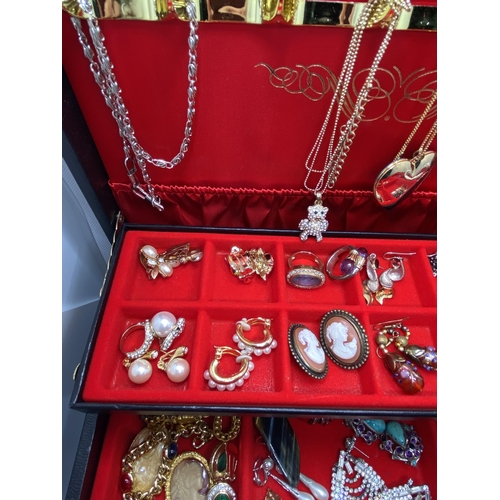 132 - A jewellery box containing a large quantity of costume jewellery to include lockets, snake rings, br... 