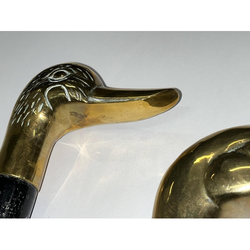 92 - Two walking sticks both featuring brass duck head designs to handle, approx. length of ebonised stic... 