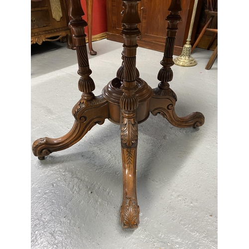 12 - Antique mahogany table with oval top, on central pedestal with ornately carved legs and castors