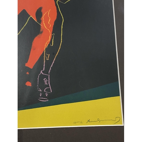 273 - Two framed prints of male form, one featuring speed skater by Andy Warhol