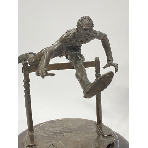 75 - A Bronze hand sculpture of an Olympic hurdler on wooden swivel base, approx. overall height 15cm