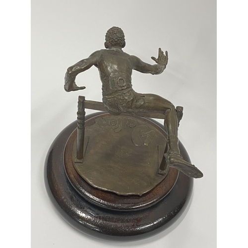 75 - A Bronze hand sculpture of an Olympic hurdler on wooden swivel base, approx. overall height 15cm