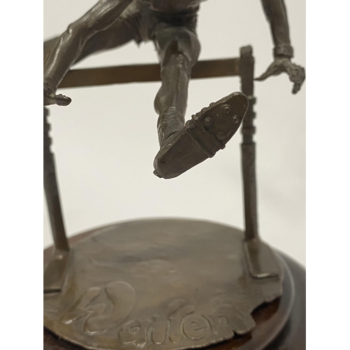 75 - A Bronze hand sculpture of an Olympic hurdler on wooden swivel base, approx. overall height 15cm