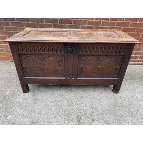 9 - Large antique oak hinged wooden chest with heavy carved detailing to front panel