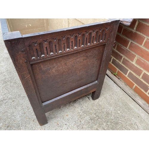 9 - Large antique oak hinged wooden chest with heavy carved detailing to front panel