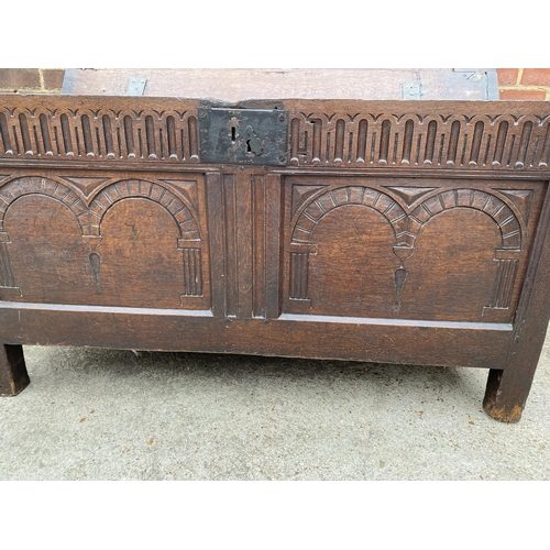 9 - Large antique oak hinged wooden chest with heavy carved detailing to front panel