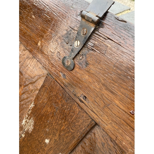 9 - Large antique oak hinged wooden chest with heavy carved detailing to front panel